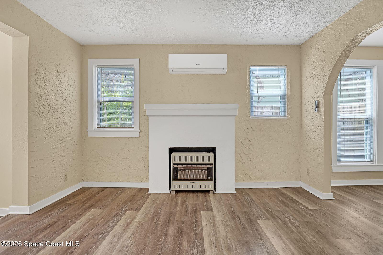 658 Young Street Melbourne, FL 32935 - Photo 22 of 77 an empty room with wooden floor a cabinet and windows