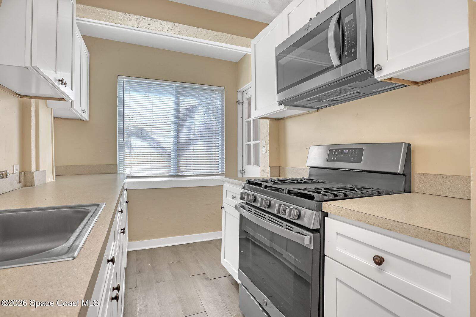 658 Young Street Melbourne, FL 32935 - Photo 29 of 77 a kitchen with granite countertop a stove and a sink