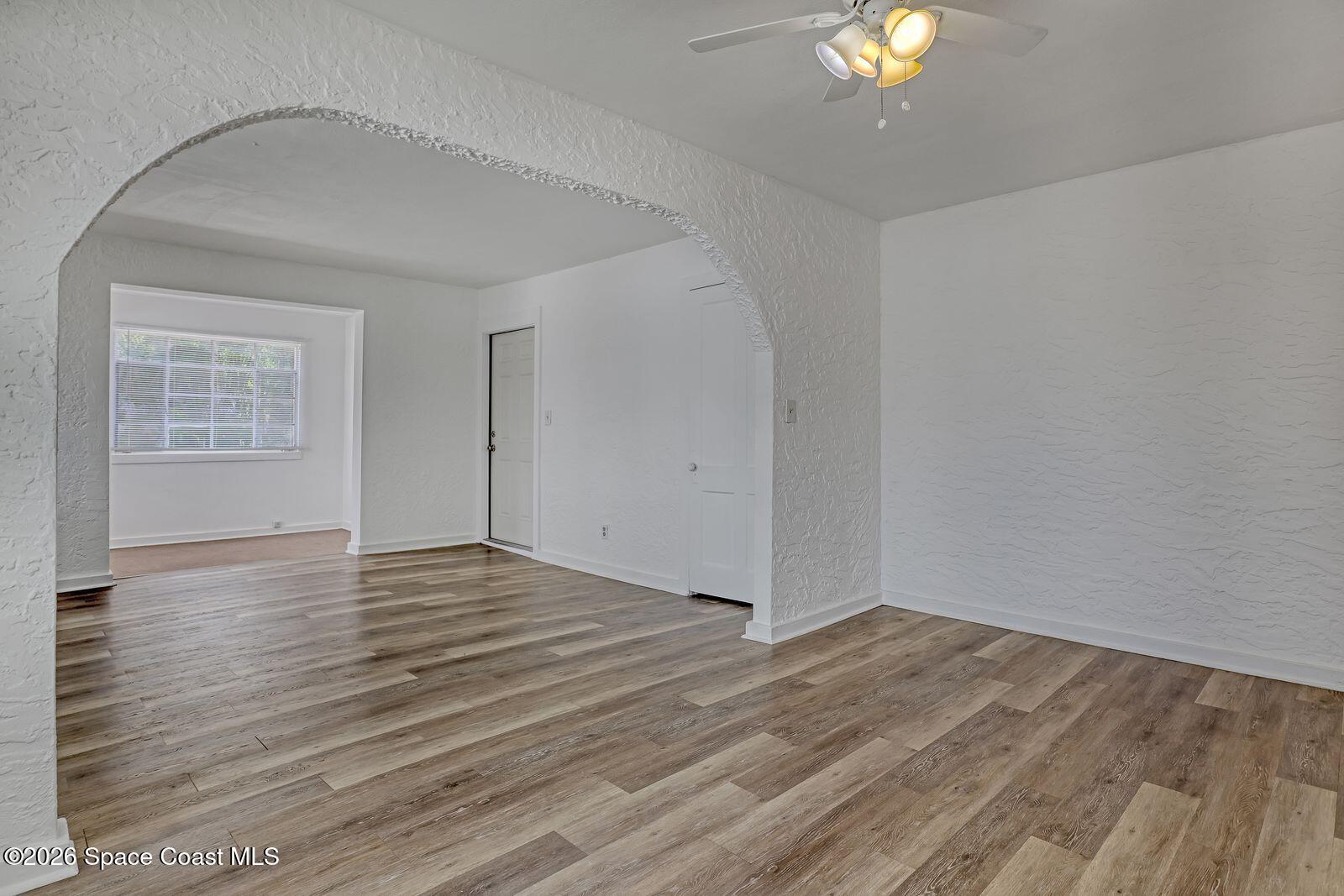 658 Young Street Melbourne, FL 32935 - Photo 8 of 77 a view of an empty room with wooden floor and a window