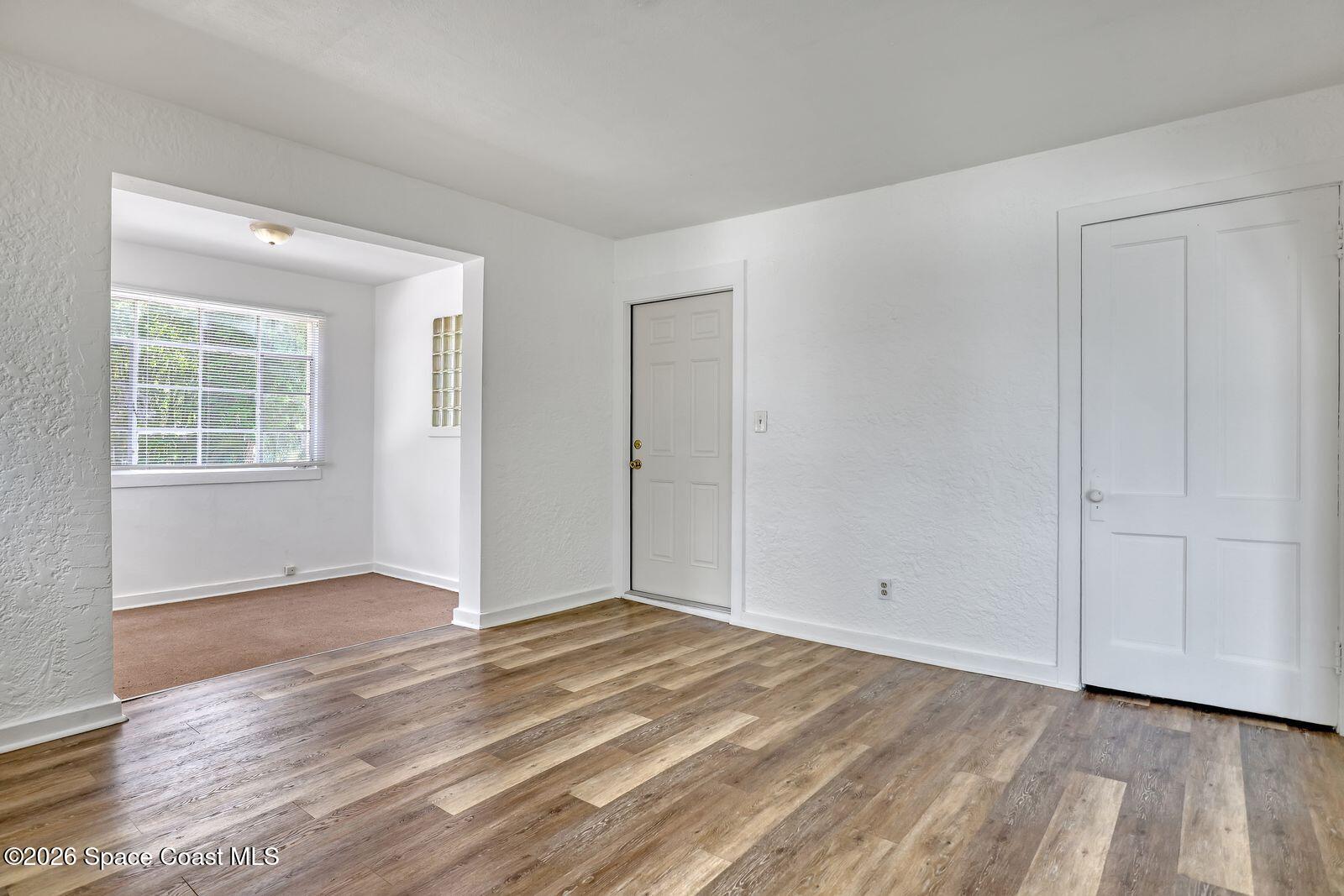 658 Young Street Melbourne, FL 32935 - Photo 10 of 77 an empty room with wooden floor and windows