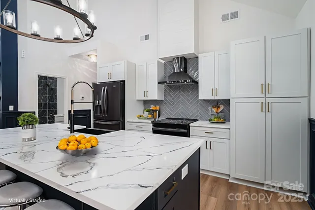 a kitchen with stainless steel appliances granite countertop a sink a stove and refrigerator