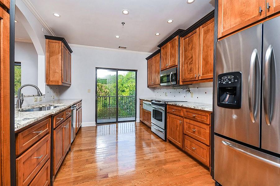 2865 Lenox Road Northeast, Unit 407 Atlanta, GA 30324 - Photo 10 of 27 a kitchen with stainless steel appliances granite countertop a stove a sink dishwasher a refrigerator and a microwave oven with wooden floor
