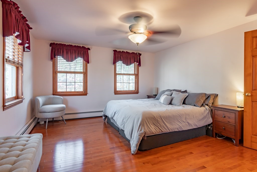 38 Westview Road Brookline, NH 03033 - Photo 11 of 28 a bedroom with a bed and a chandelier