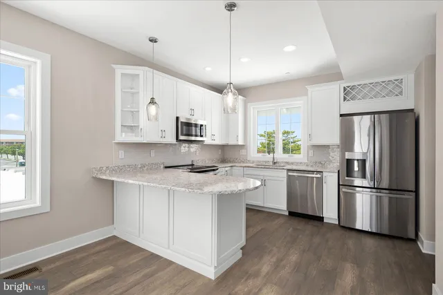 a kitchen with stainless steel appliances granite countertop a refrigerator a stove top oven a sink and dishwasher