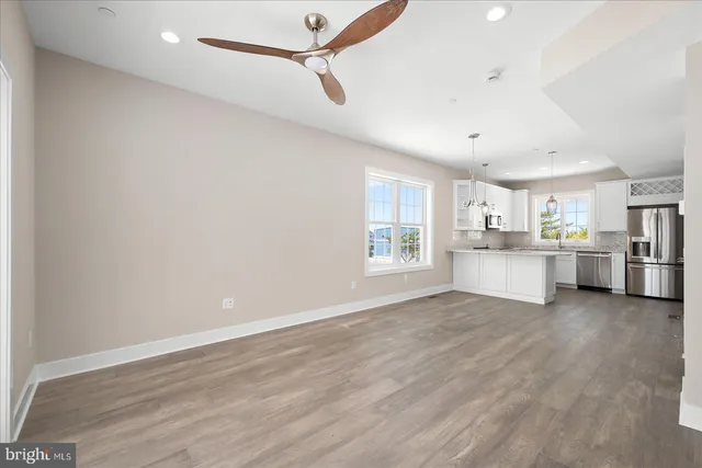a view of a kitchen with wooden floor and windows