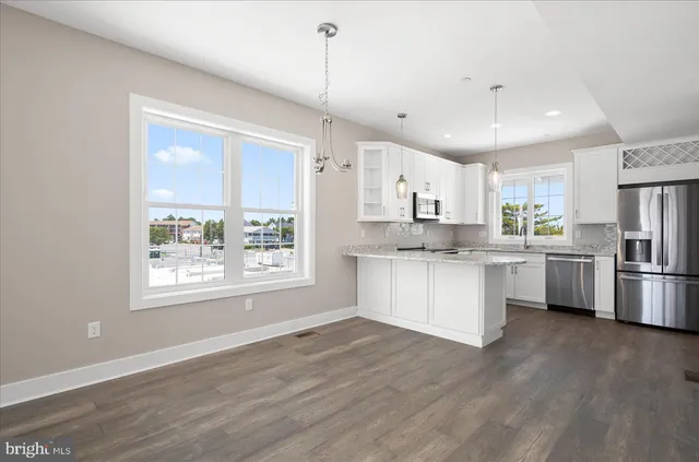 a kitchen with white cabinets and window