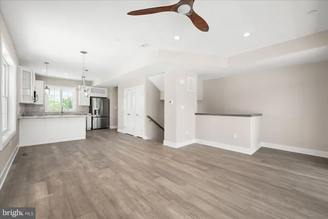 a kitchen with a refrigerator a sink dishwasher a stove and white cabinets with wooden floor