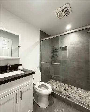 a bathroom with a sink a toilet and shower