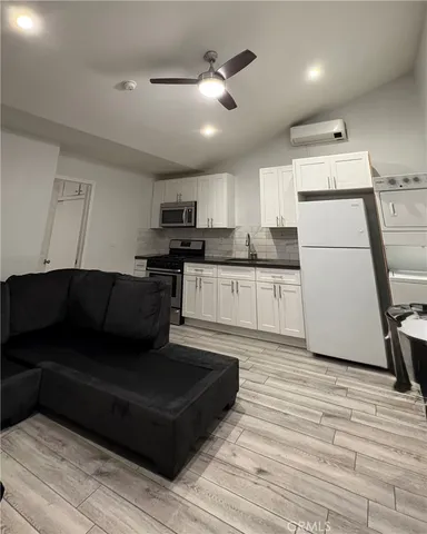 a living room with stainless steel appliances kitchen island granite countertop furniture and a fireplace