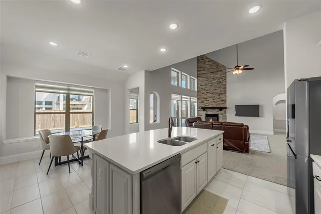 a kitchen with kitchen island a sink stainless steel appliances and window