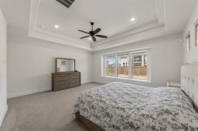 a bed room with a bed and a ceiling fan