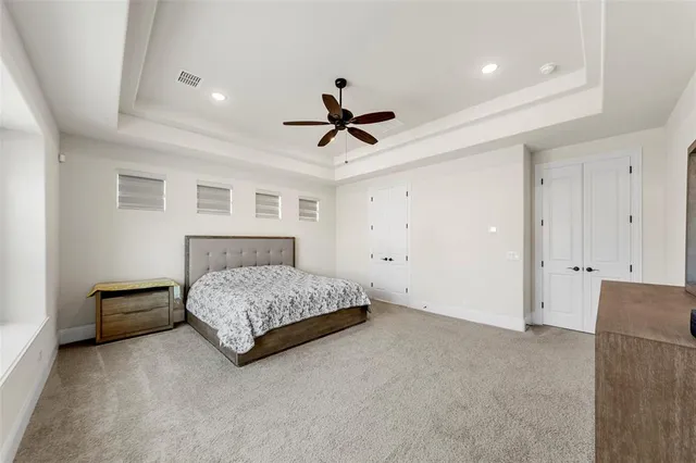 a spacious bedroom with a bed a chandelier and a window
