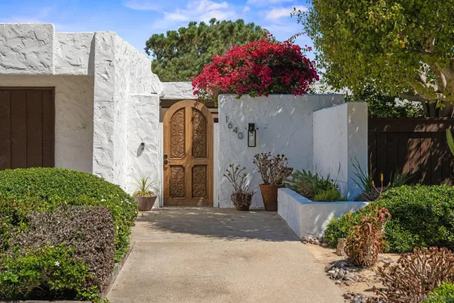 a front view of a house with yard and flowers