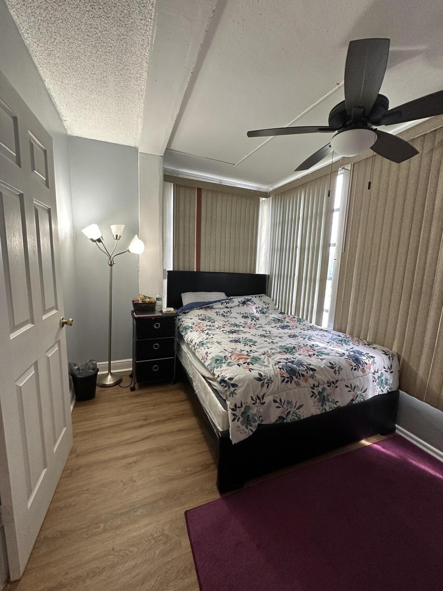 8341 Sands Point Boulevard, Unit B206 Tamarac, FL 33321 - Photo 9 of 11 a bedroom with a bed and a mirror