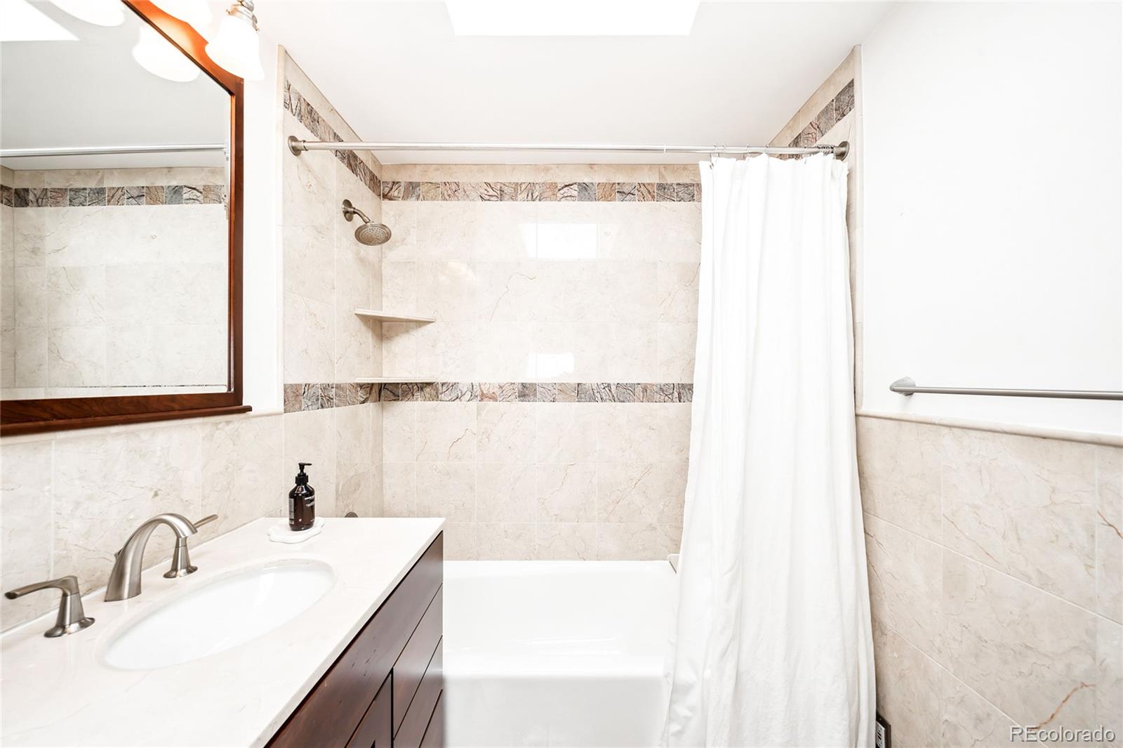 950 South Monroe Street Denver, CO 80209 - Photo 30 of 39 a bathroom with a granite countertop sink and a mirror