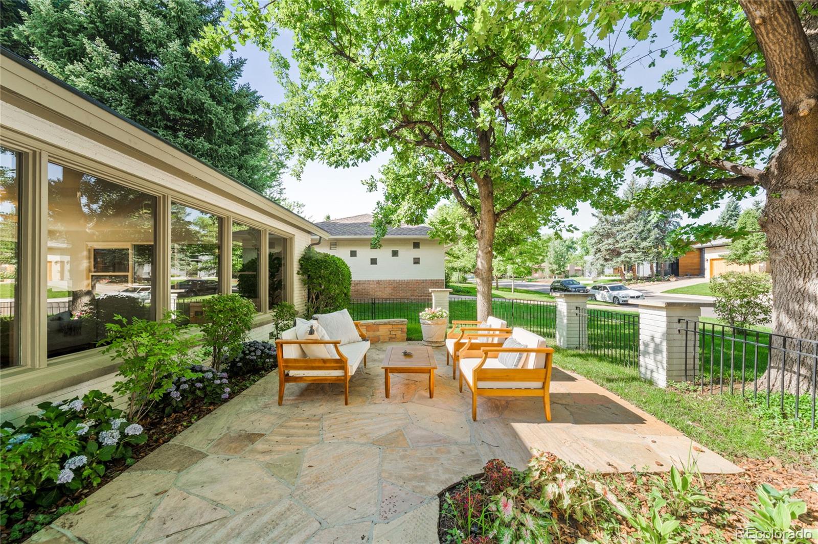 950 South Monroe Street Denver, CO 80209 - Photo 3 of 39 a view of a patio with table and chairs potted plants and large tree