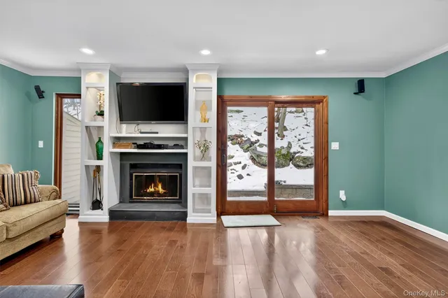 a living room with furniture a flat screen tv and a fireplace