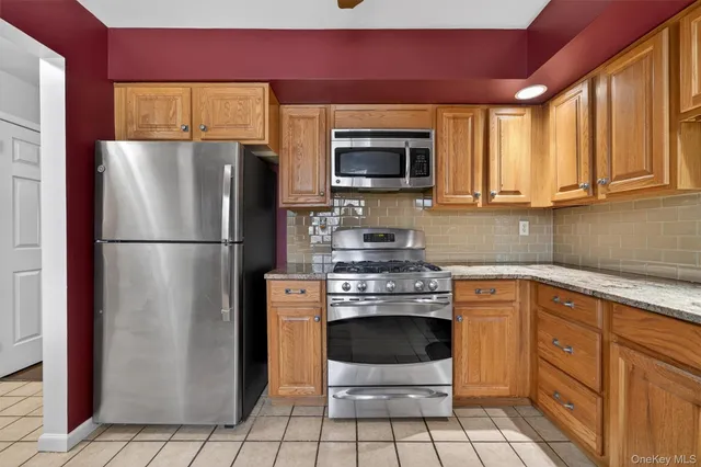 a kitchen with stainless steel appliances granite countertop a refrigerator stove and sink