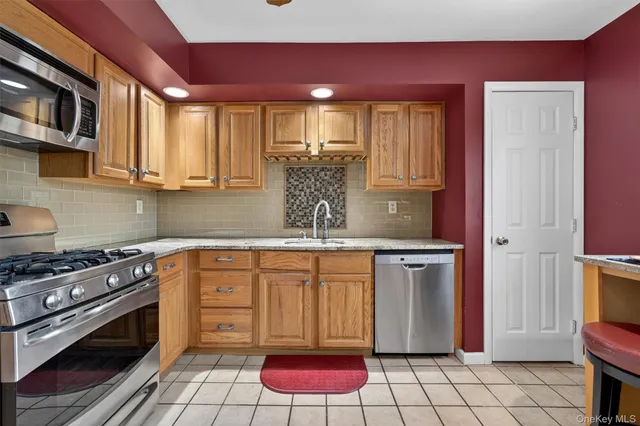 a kitchen with stainless steel appliances granite countertop a refrigerator sink and stove