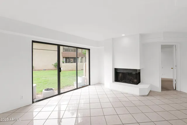 a view of an empty room with a fireplace and a window