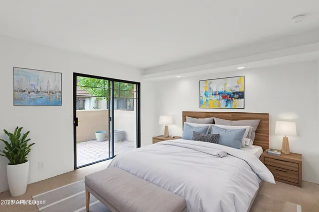 a bedroom with a large bed and a painting on the wall