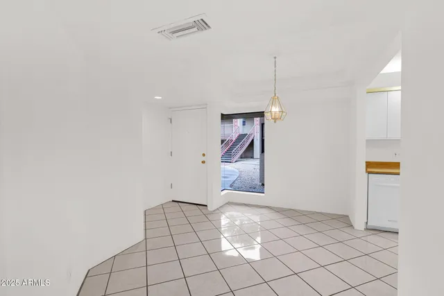 a view of an empty room and kitchen view