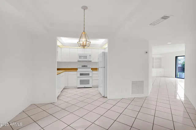 a view of empty room with kitchen