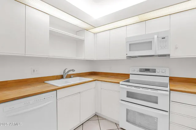 a kitchen with granite countertop white cabinets and white appliances