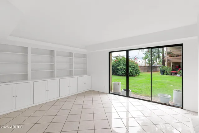 a view of an empty room with a large window and wooden floor