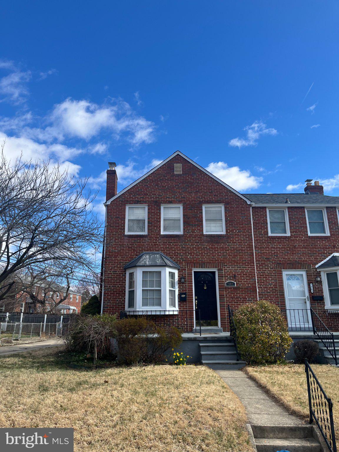 Charming brick home under blue skies.
