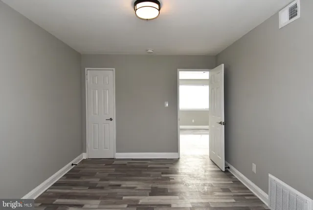 a view of empty room with wooden floor
