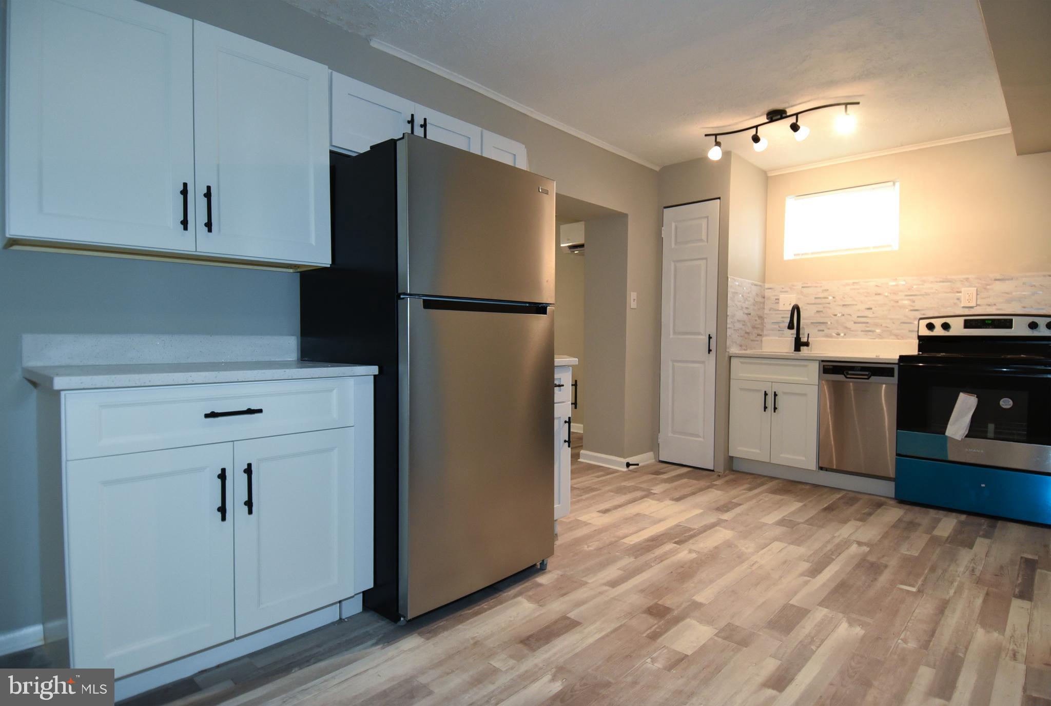 8208 Bellefonte Lane, Unit 2 Clinton, MD 20735 - Photo 32 of 38 a kitchen with kitchen island a counter top space wooden floor and appliances