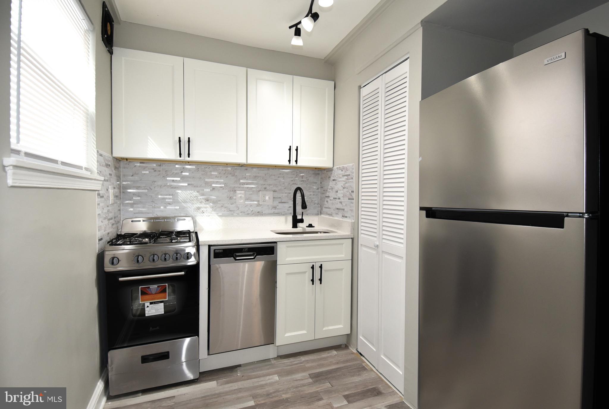 8208 Bellefonte Lane, Unit 2 Clinton, MD 20735 - Photo 7 of 38 a kitchen with a sink and a stove top oven