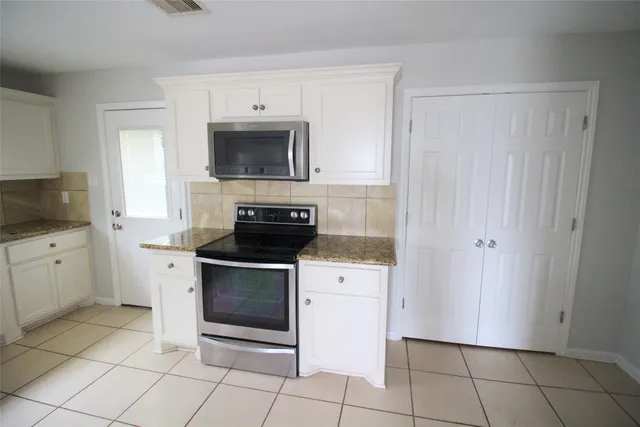 a kitchen with a refrigerator and a stove