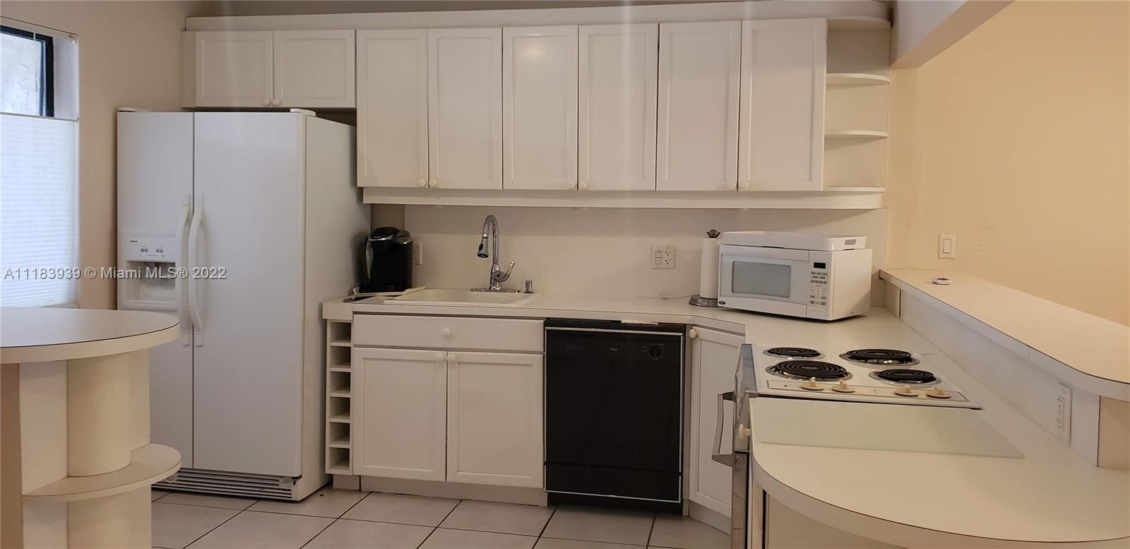 370 Racquet Club Road, Unit 103 Weston, FL 33326 - Photo 3 of 16 a kitchen with a white stove top oven and sink