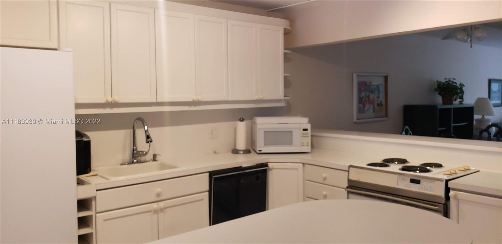 370 Racquet Club Road, Unit 103 Weston, FL 33326 - Photo 4 of 16 a kitchen with a white cabinets and appliances