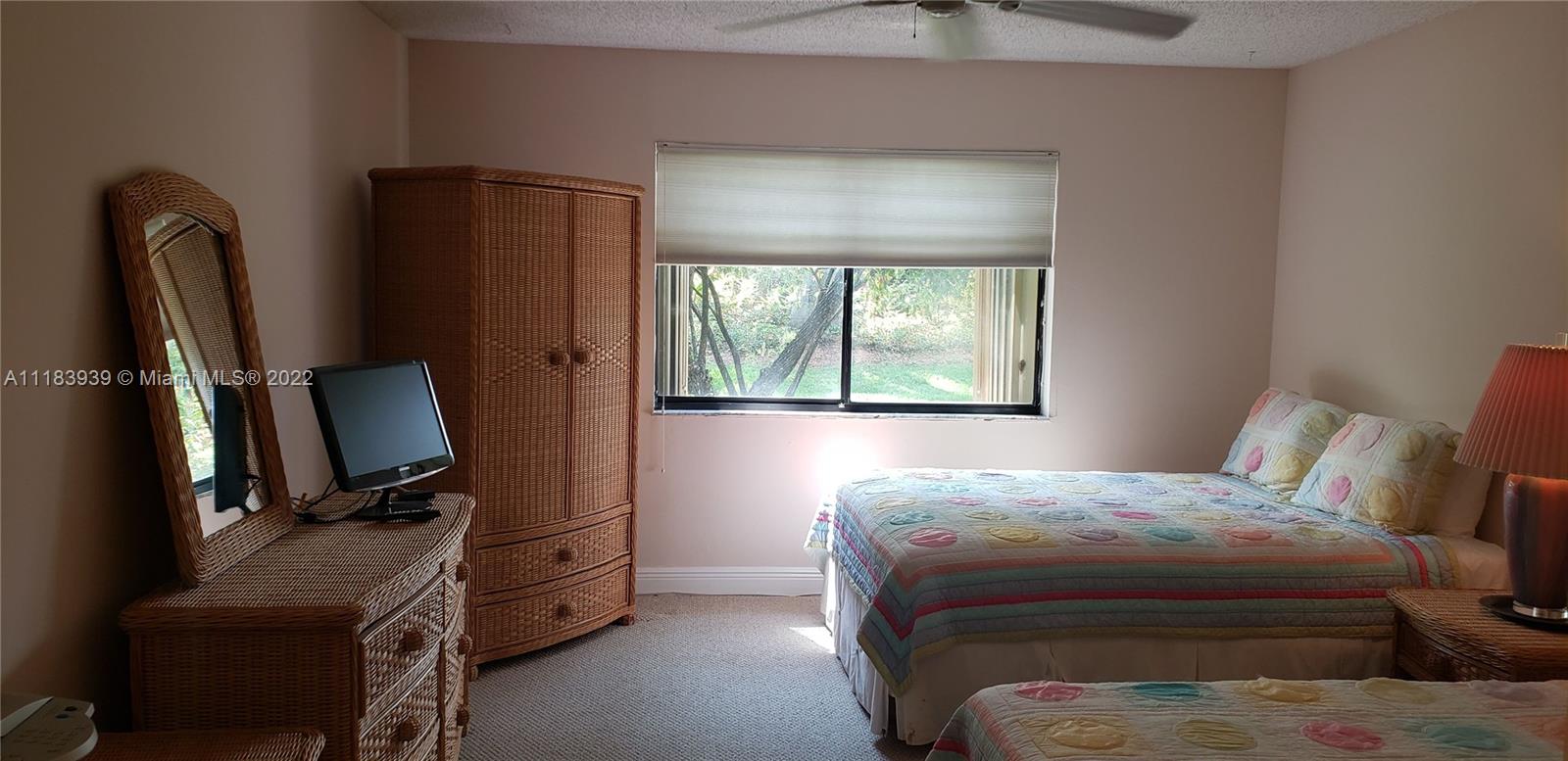 370 Racquet Club Road, Unit 103 Weston, FL 33326 - Photo 9 of 16 a bedroom with a bed and a mirror