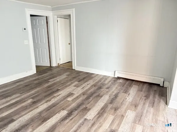 a view of an empty room with wooden floor