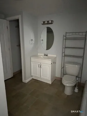 a bathroom with a toilet a sink and a mirror
