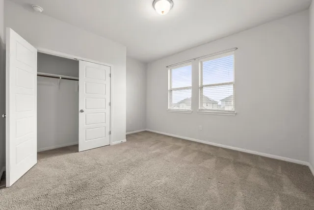 an empty room with windows and closet