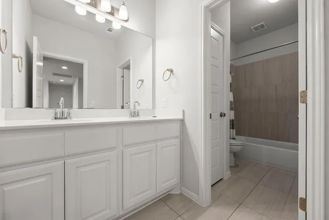 a bathroom with a double vanity sink mirror and shower