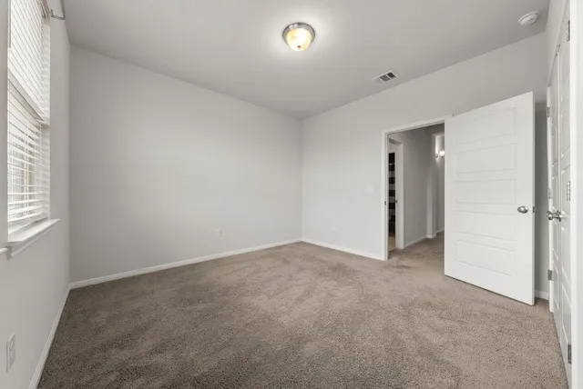 an empty room with windows and closet