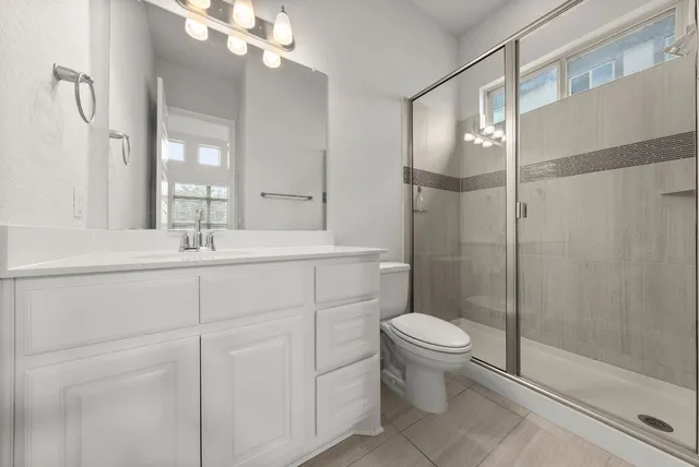 a bathroom with a sink a toilet and shower