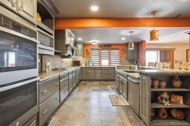 a kitchen with stainless steel appliances granite countertop a refrigerator and a stove top oven