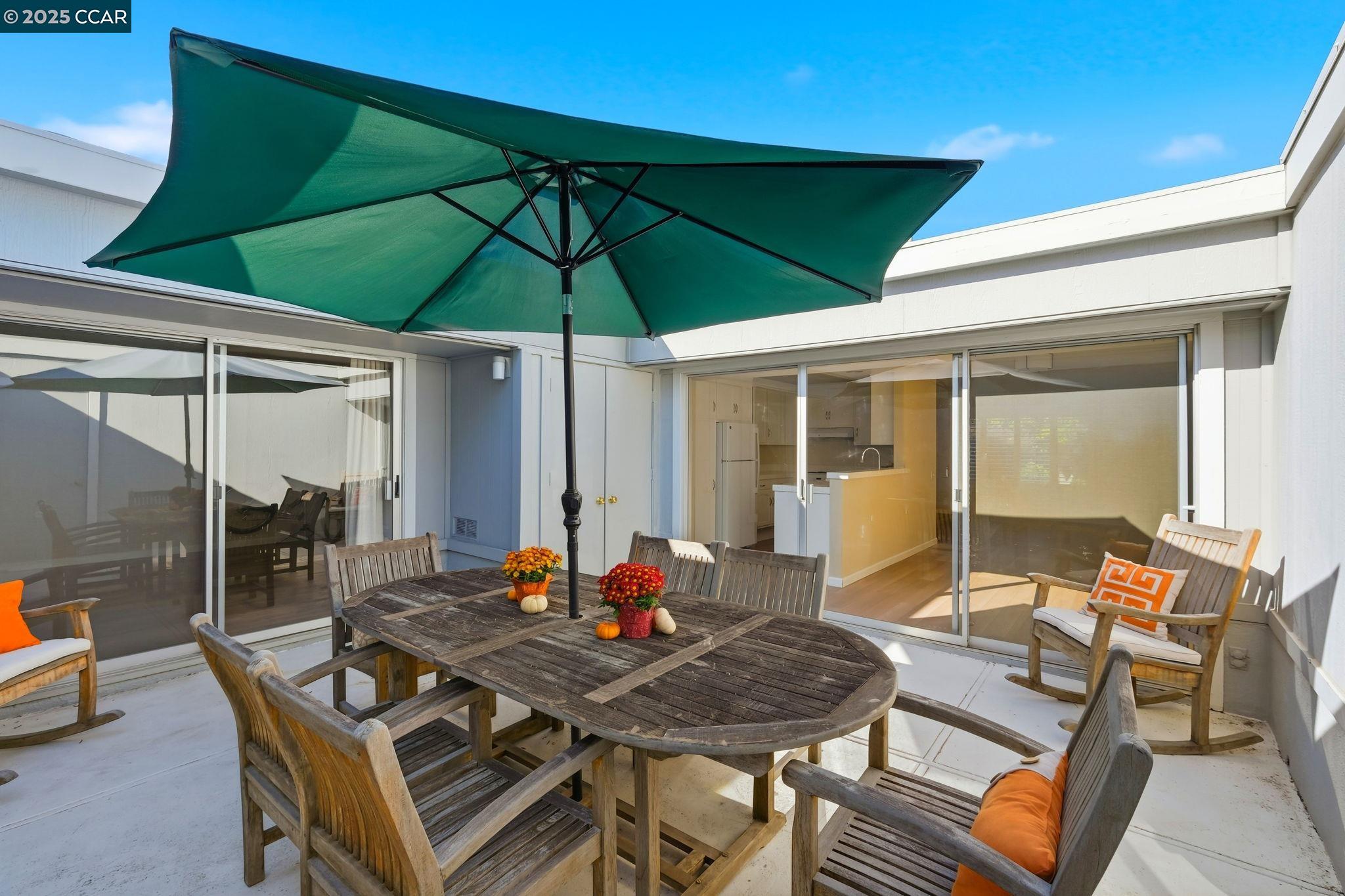 2425 Pine Knoll Drive, Unit 1 Walnut Creek, CA 94595 - Photo 22 of 43 a patio with a table and chairs under an umbrella
