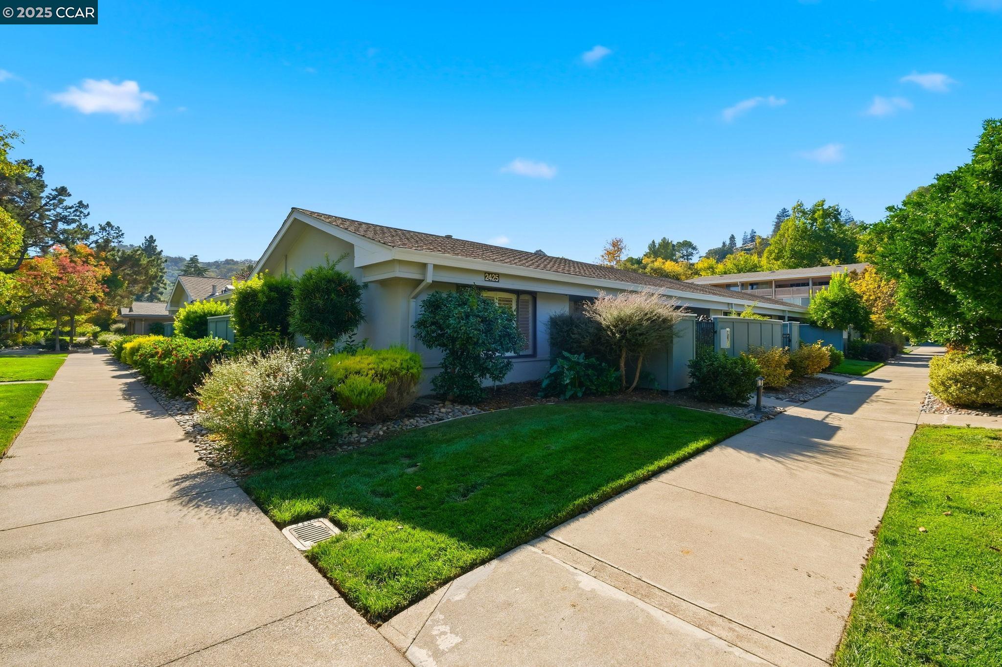 2425 Pine Knoll Drive, Unit 1 Walnut Creek, CA 94595 - Photo 24 of 43 a front view of a house with a garden and plants