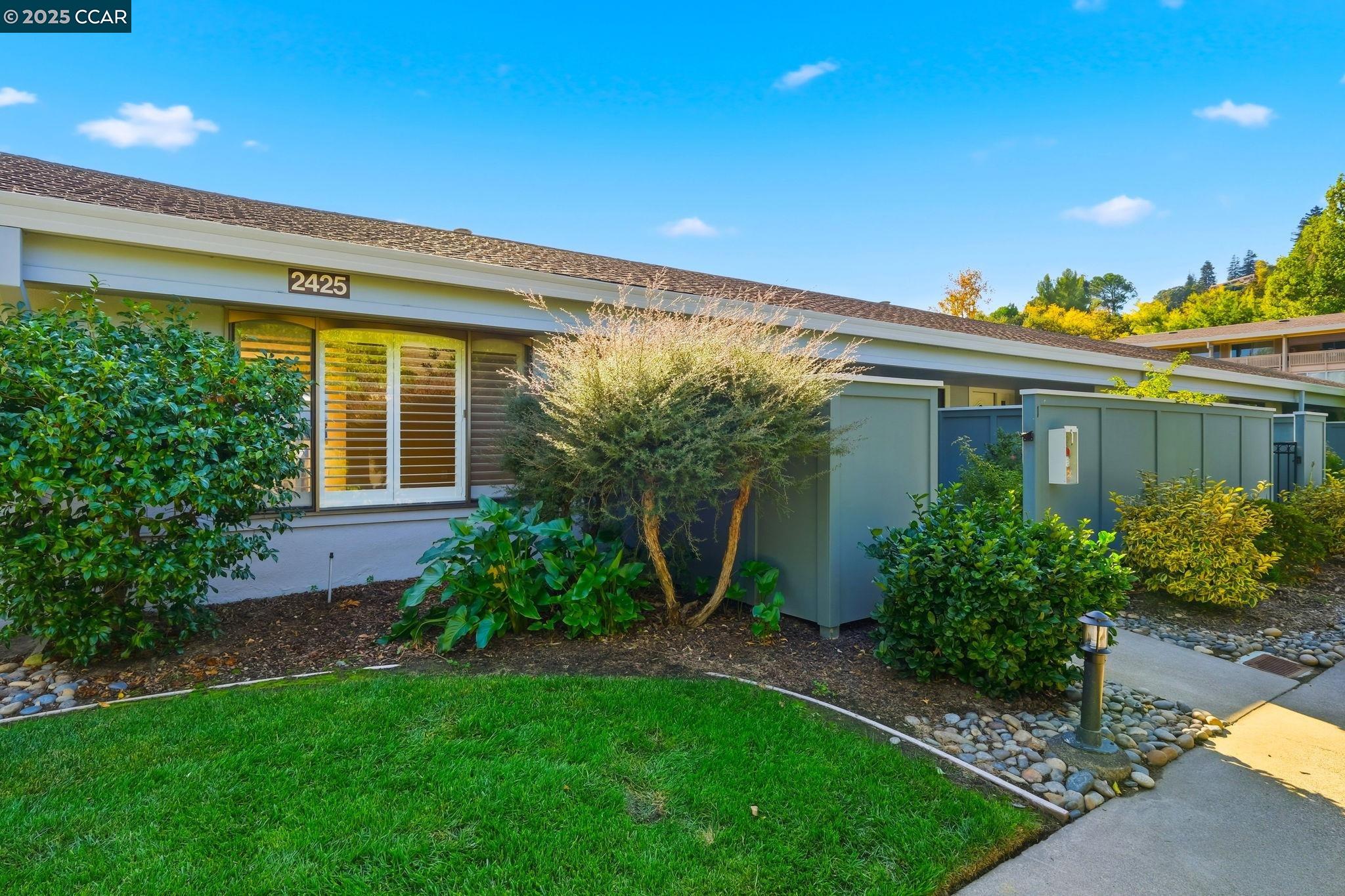 2425 Pine Knoll Drive, Unit 1 Walnut Creek, CA 94595 - Photo 26 of 43 a view of a house with brick walls and a yard with plants