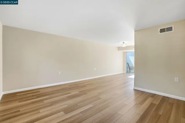 a view of an empty room with wooden floor