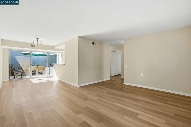 a view of a livingroom with wooden floor and a ceiling fan