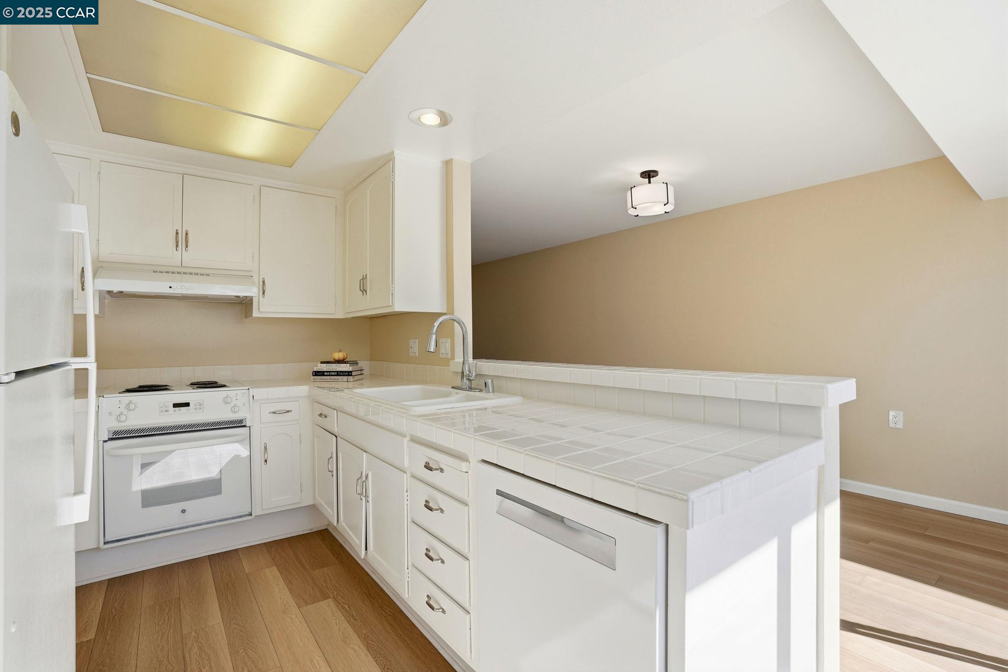 2425 Pine Knoll Drive, Unit 1 Walnut Creek, CA 94595 - Photo 7 of 43 a kitchen with granite countertop white cabinets and white appliances